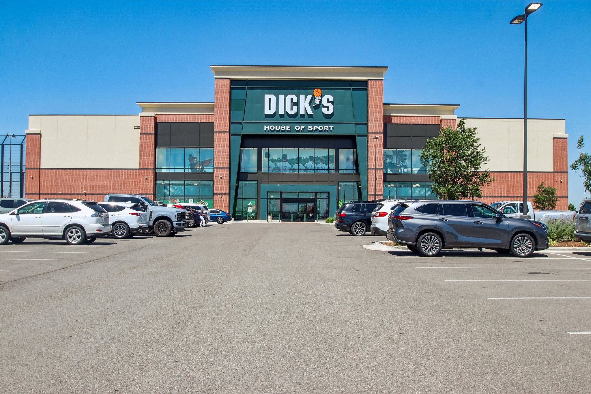 A Dick's Sporting Goods store with cars parked in front.